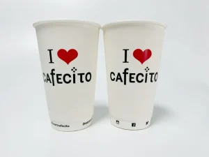 Disposable paper cups with a simple "I Love Cafecito" design in black and red, printed using the AP-600-8 Automatic Cup Printing Machine. Showcases clear, single-color prints on disposable paper cups for beverage packaging.